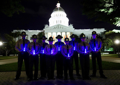 Deputies holding blue lights in front of capital at night
