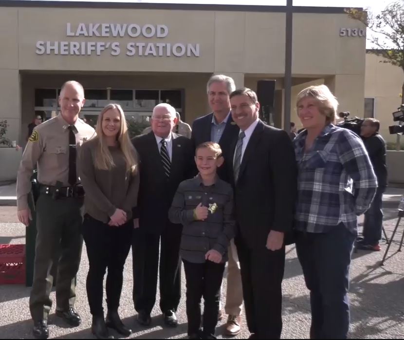 Sheriff's Captain and people standing next to building