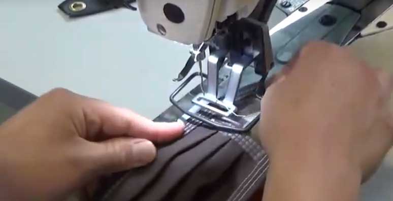 Close up of hands worning on a Sewing machine.