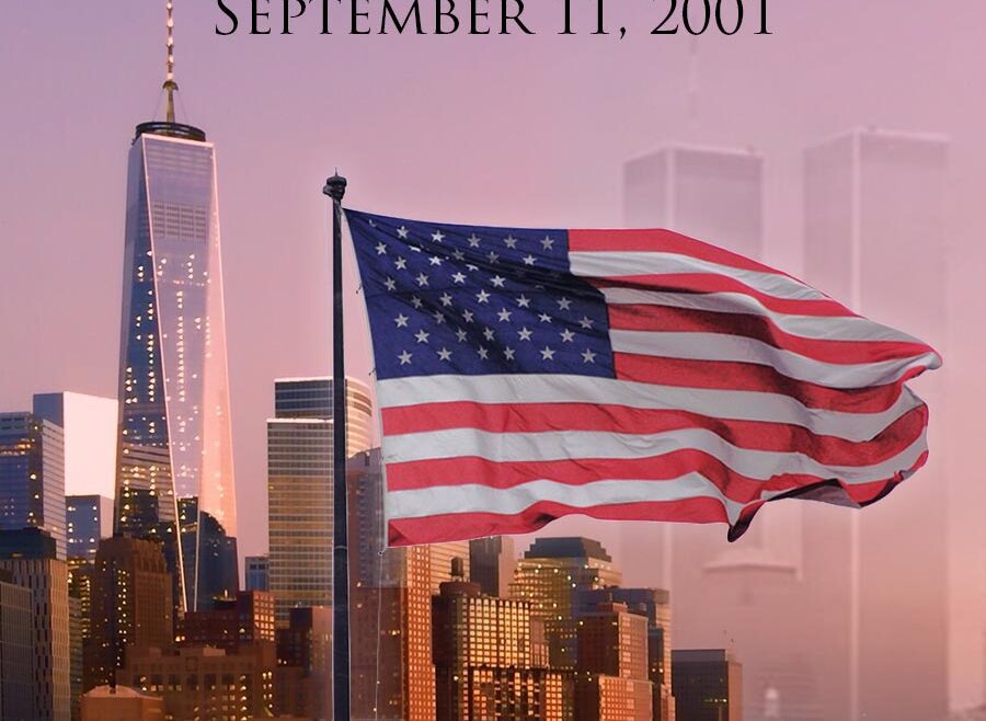 We Will Never Forget, September 11, 2001. Image of the american flag waving over the One Trade Center Tower on the left of flag and the Right side of flag are the Twin towers very faint over the orange purple sky.