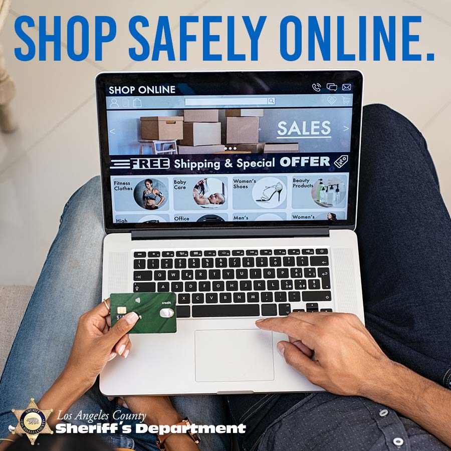 a couple is shopping online, they are sitting on a couch both using a computer. the camera is looking at the computer and keyboard, the wife is holding the credit card and the husband is navigating on the keyboard.