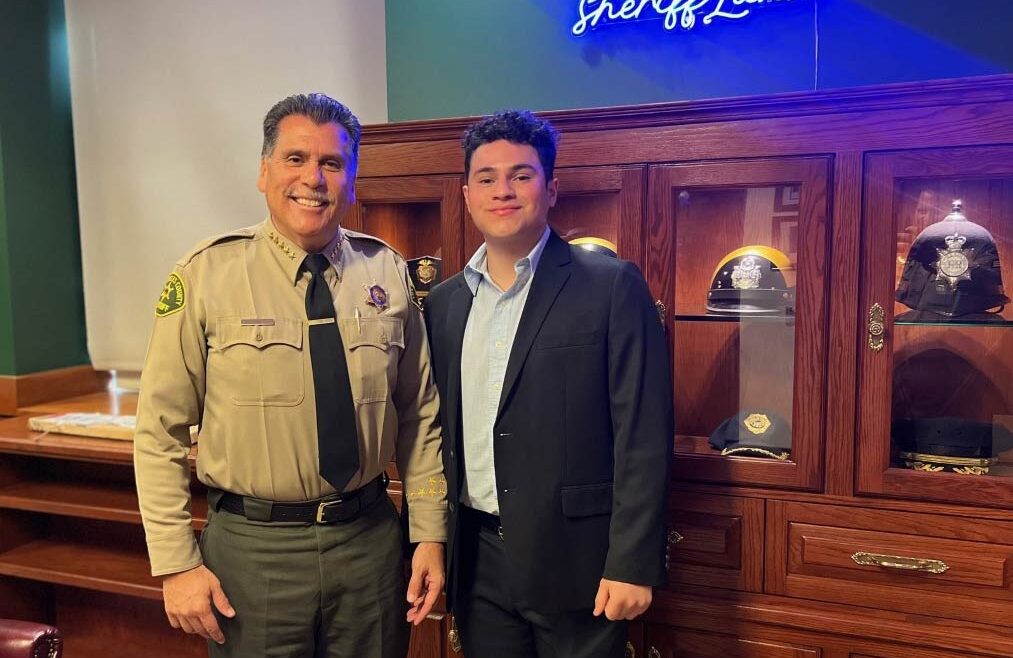 Luis standing next to sheriff luna. Luna is in uniform.