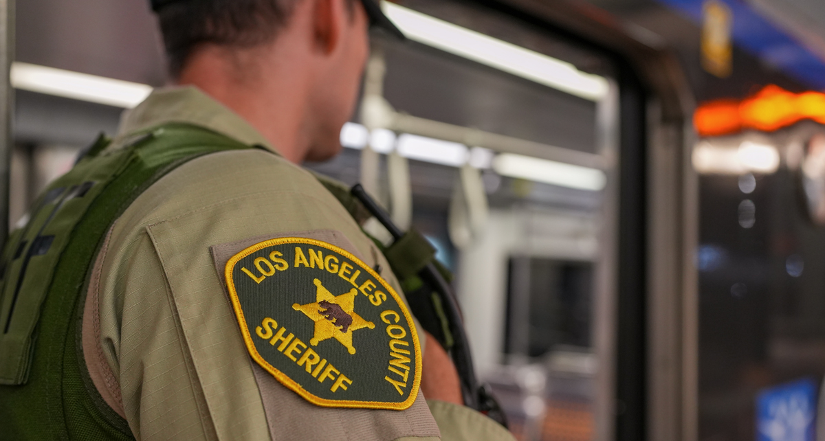 Picture of a Deputy on a train. The deputy's should is towards the camera and the patch is shown on his shoulder.
