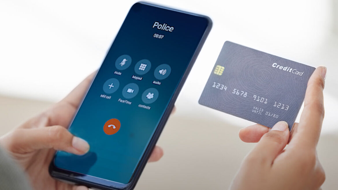 Person holding a cell phone; caller ID on screen says "Police"; the person is holding a credit card in their other hand